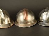 three helmets that are sitting on a black surface