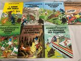 quatre livres pour enfants posés sur un lit recouvert d'un drap blanc