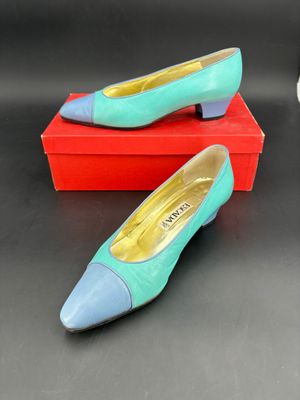 une paire de chaussures bleues et vertes posées sur une boîte rouge