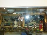 une vitrine en verre avec un tableau accroché au mur derrière