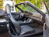 the interior of a car with the door open and the driver ' s seat down