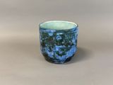 a blue and green cup sitting on a table