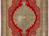 a red and beige rug with a medallion design on it