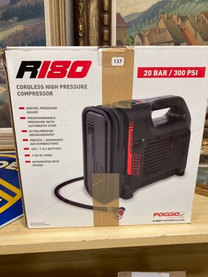 une photo d'un carton contenant un compresseur d'air portable posé sur une étagère