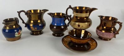 cinq vases de couleurs différentes posés sur une surface blanche