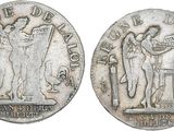 a close up of a silver coin with a woman holding a flag