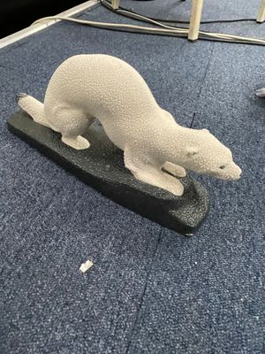 sculpture représentant un ours polaire assis sur un bloc de bois