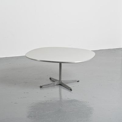 une image représentant une table blanche posée sur un sol en béton