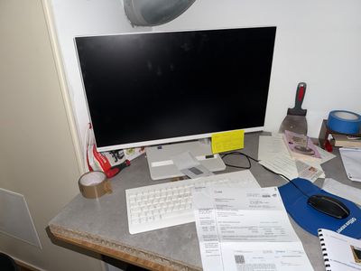 un bureau sur lequel se trouvent un écran d'ordinateur, un clavier, une souris et d'autres objets