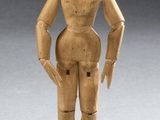 an image of a wooden doll standing in the middle of a room