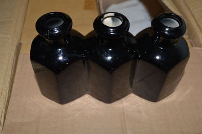 trois bouteilles noires vides posées sur une boîte en carton