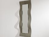un miroir accroché au mur à côté d'un lavabo