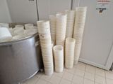de nombreuses piles de tasses posées par terre à côté d'une poubelle