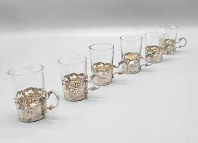 six verres à shot alignés sur une surface blanche