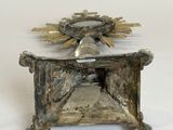 a small silver box with a bell on top of it