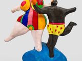 a figurine of a man and a dog playing with a ball