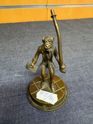 une statue en bronze représentant un singe tenant une batte de baseball