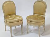 pair of chairs with upholstered seats and padded seat cushions