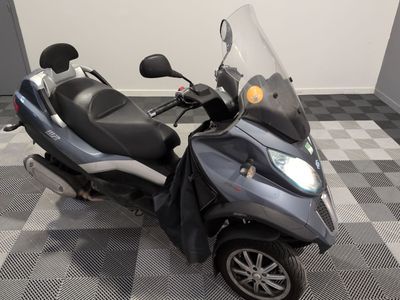 un scooter garé sur un sol à damier