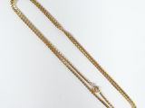 an image of a gold chain with a white diamond on it