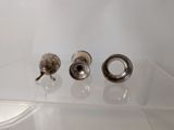 three pieces of metal on a clear shelf