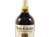 une vieille bouteille de vin posée sur une surface blanche