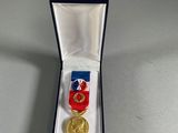 an image of a medal in a box with a ribbon around it
