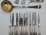 a lot of knives and spoons that are on the table