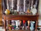 a wooden shelf with many different vases and glasses on it
