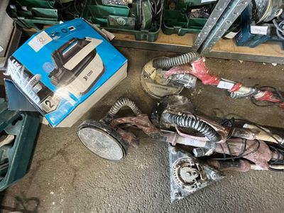 une boîte contenant des aspirateurs posée par terre à côté d'autres objets