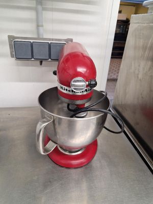 un mixeur rouge posé sur le plan de travail de la cuisine