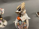 a figurine of a woman holding a basket of flowers