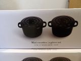 two black pots sitting on top of a white box