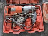 une mallette orange contenant des outils, posée par terre