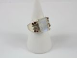 un gros plan d'une bague sertie d'une pierre blanche
