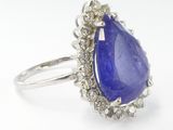 a close up of a tanzanite and diamond ring on a white background