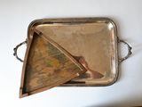 a silver tray with a painting on it on a table