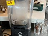 a blender that is sitting on a counter next to glasses