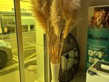 a tall vase with some flowers in it in front of a window