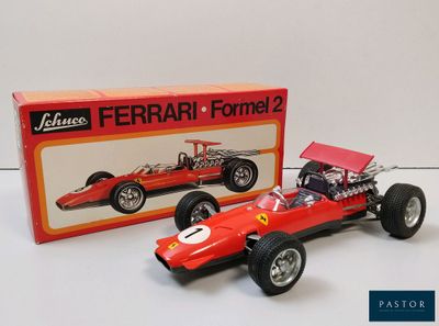 La maquette d'une voiture de course rouge se trouve à côté d'une boîte emballée