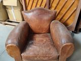 un fauteuil en cuir marron qui se trouve dans une pièce