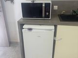une petite cuisine équipée d'un micro-ondes et d'un lave-vaisselle