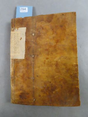 an old book with a tag on it sitting on a table