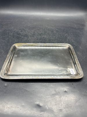 un plateau en argent posé sur une table, sur fond noir