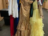 a lot of dresses hanging on a rack in a room