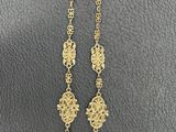 a gold necklace with black beads and a star on it