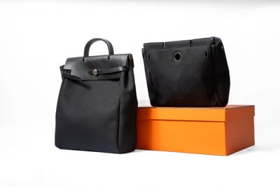 deux sacs noirs et orange posés l'un à côté de l'autre sur une surface blanche