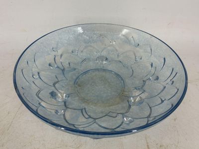 un bol en verre bleu orné d'un motif floral