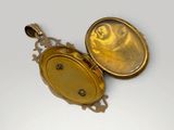 two gold lockes sitting on top of each other on a white surface
