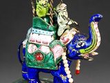 an image of a figurine of a man riding an elephant